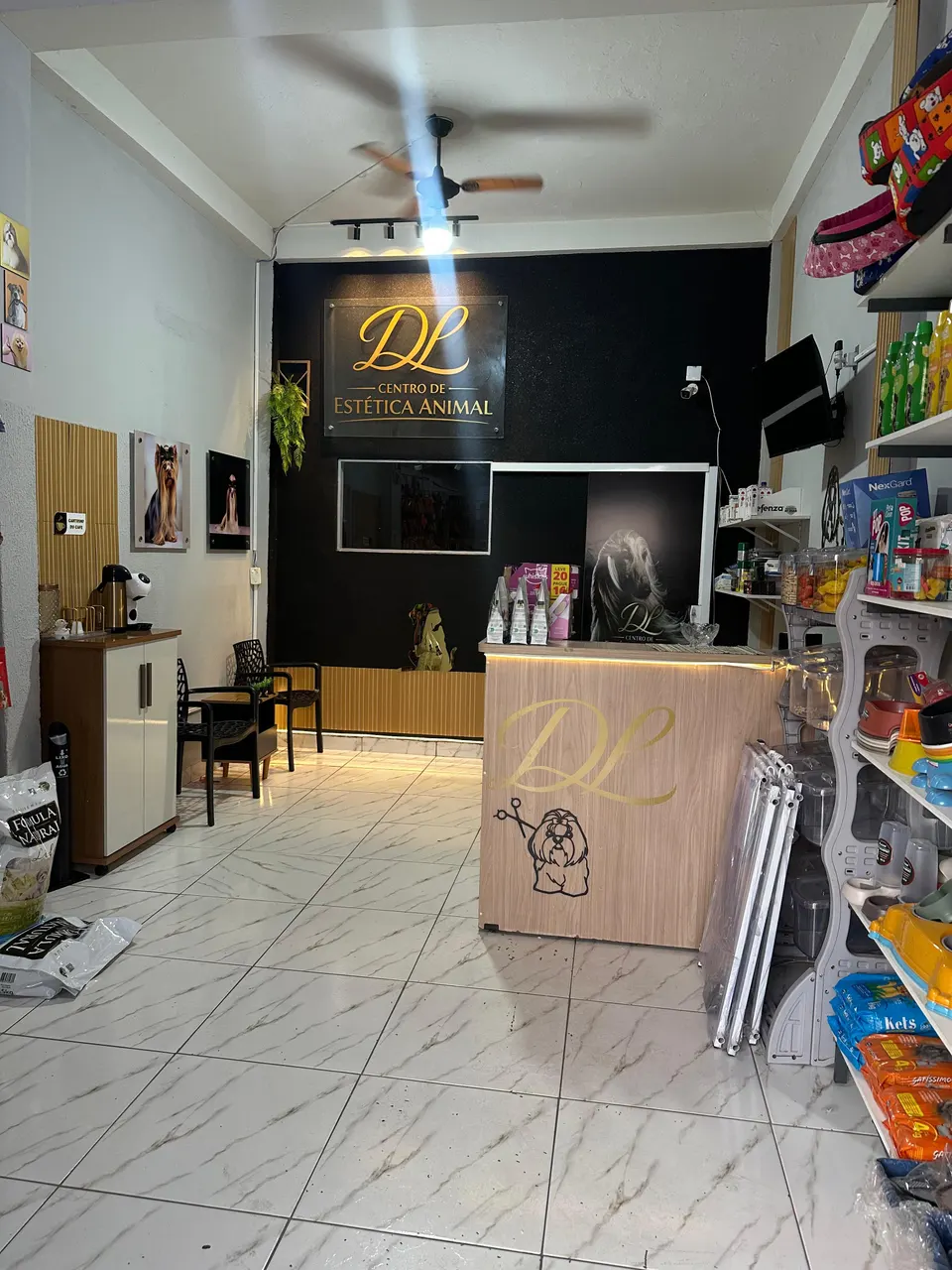 Interior da DL Rações com prateleiras cheias de rações e produtos, balcão de atendimento e parede com o logotipo